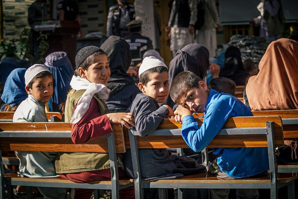 a group of children sitting on top of wooden benches