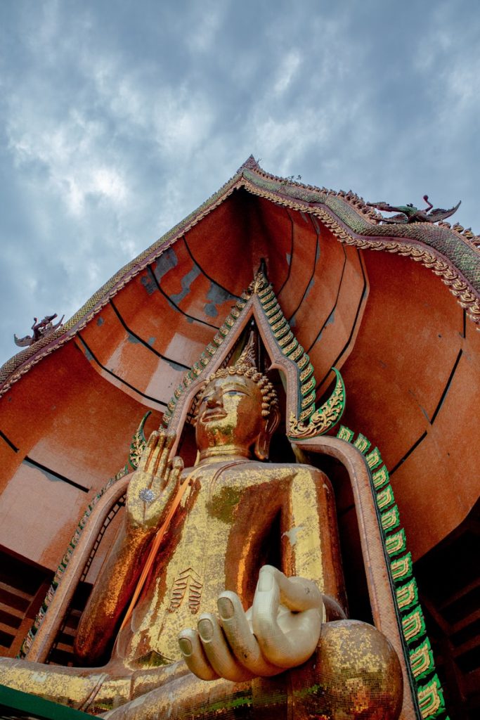 gold buddha statue under cloudy sky during daytime