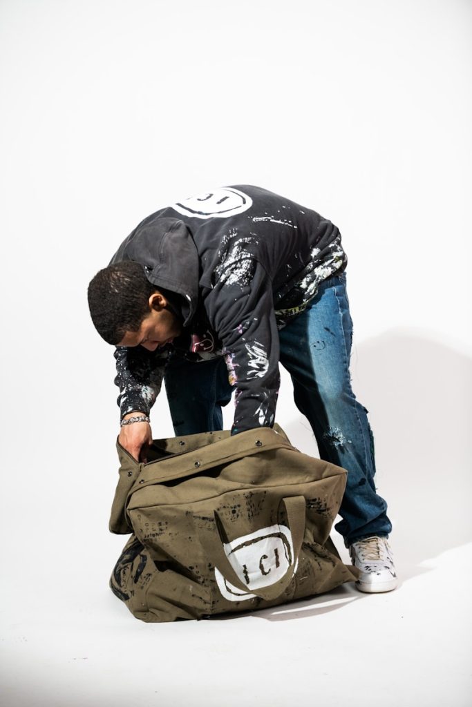 A man bending over a bag on the ground