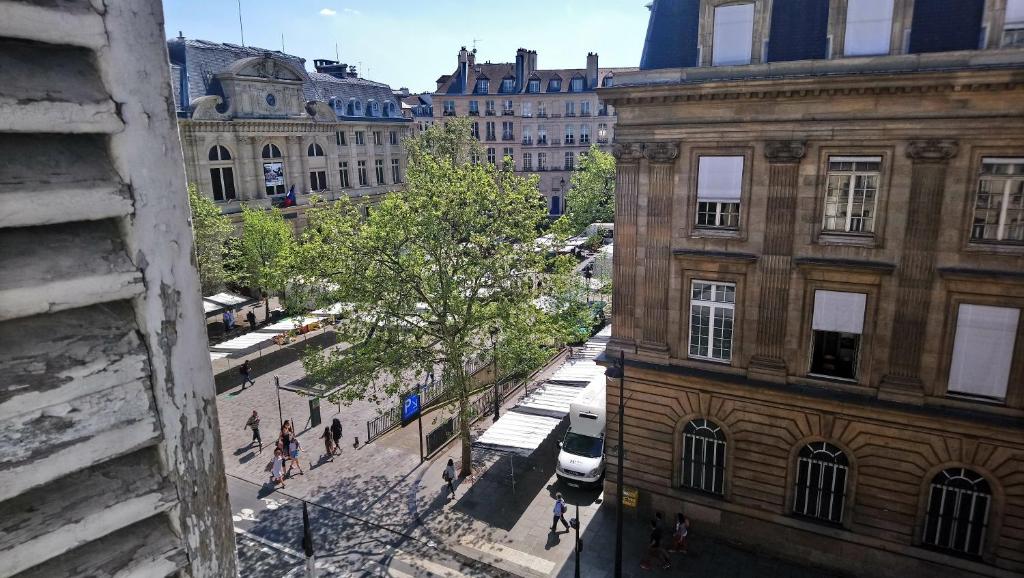 hotel room window overlooking tree and city hall in Paris