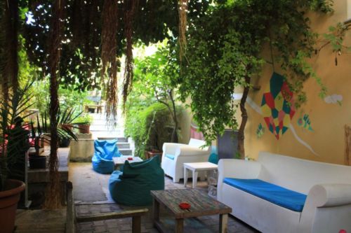 white sofa and blue bean bag chairs in garden space of The Beehive budget hotel in Rome